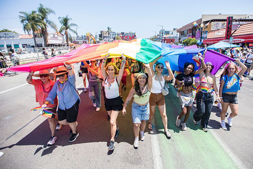 Parade participants carry a large rainbow flag at San Diego Pride in July 2026