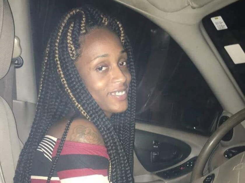 De’Janay Stanton smiling in a car with long braids and a striped top