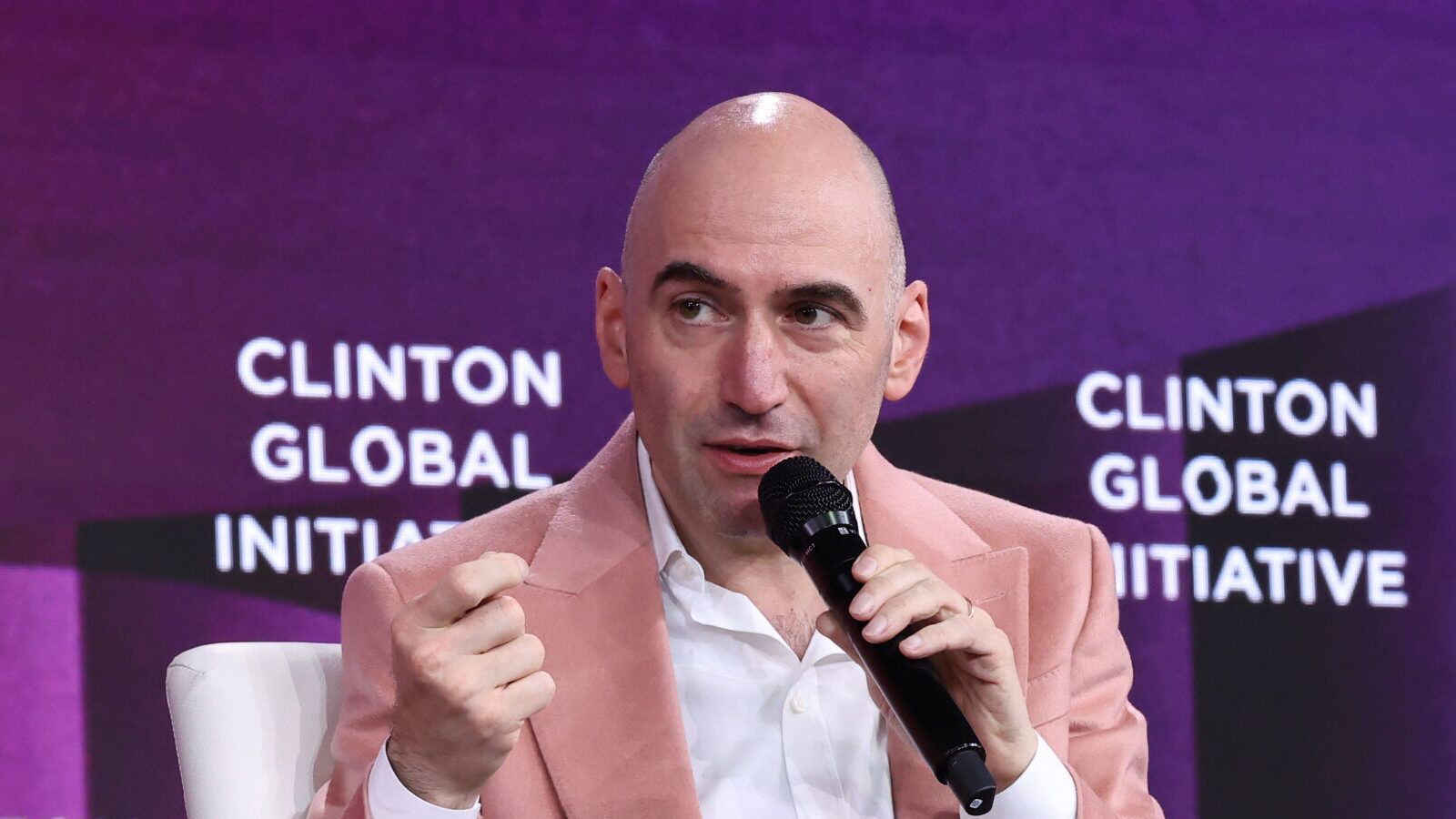 Grindr CEO George Arison speaks into a microphone at the Clinton Global Initiative.