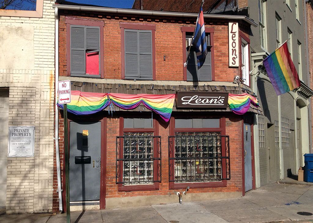 Leon’s bar on a Baltimore street corner, with a rainbow flag above its entrance.