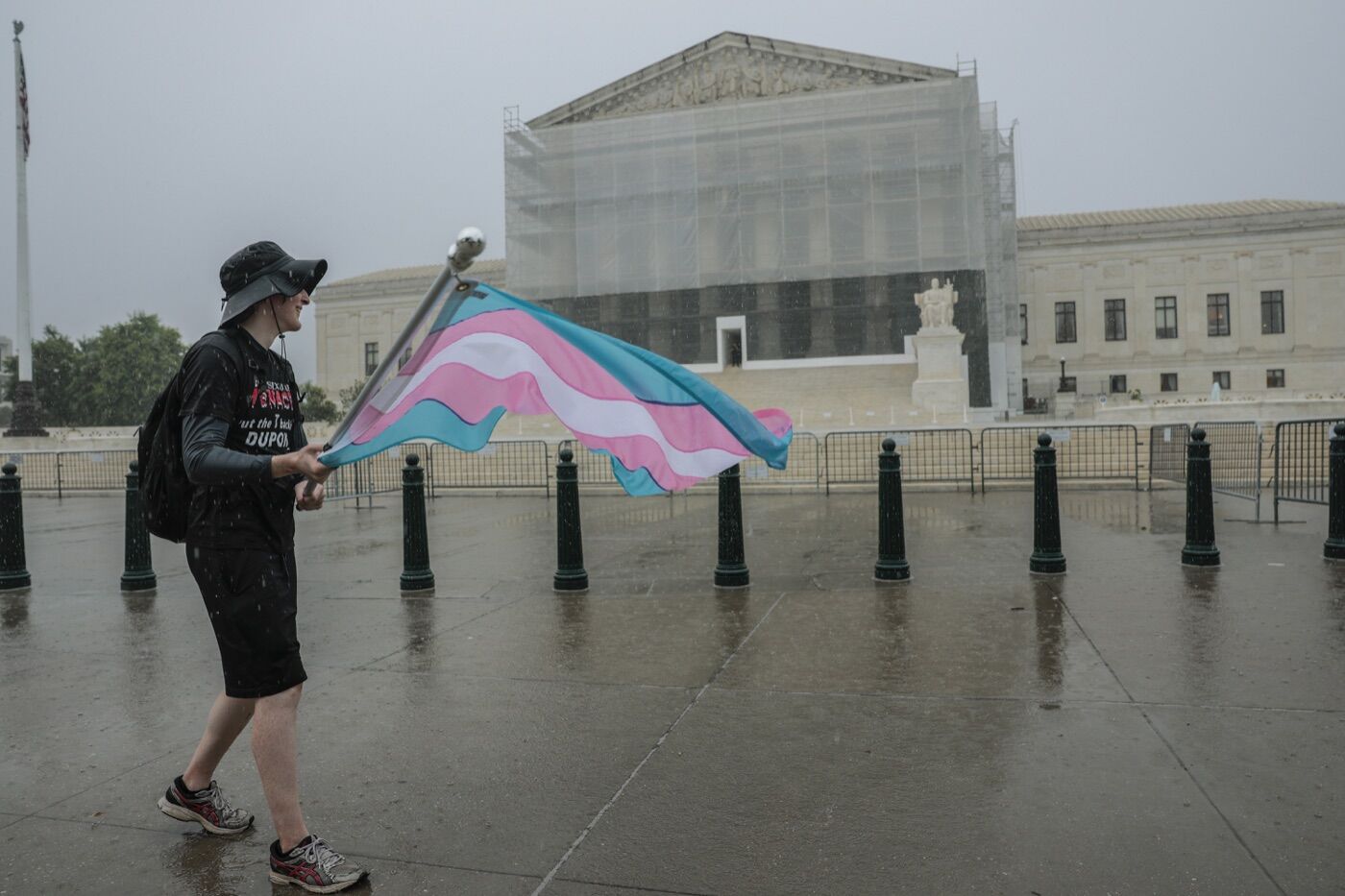 A protester waves a transgender pride flag outside the U.S. Supreme Court in June 2025.