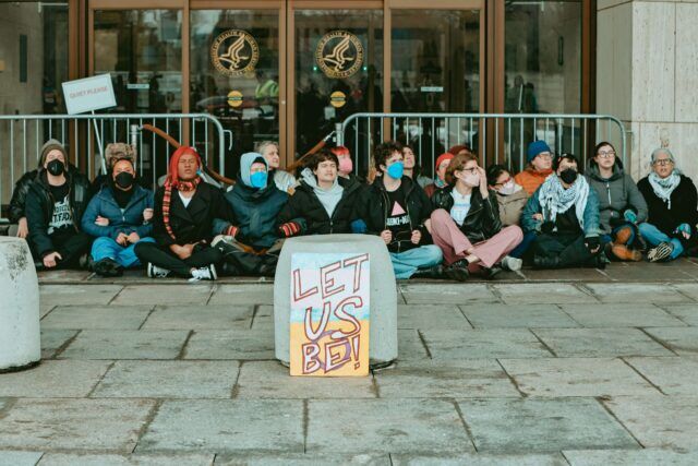 Vingt-quatre personnes ont été arrêtées après que des militants ont bloqué le HHS au sujet de règles proposées qui pourraient interrompre les soins d'affirmation de genre pour les jeunes trans dans tout le pays.